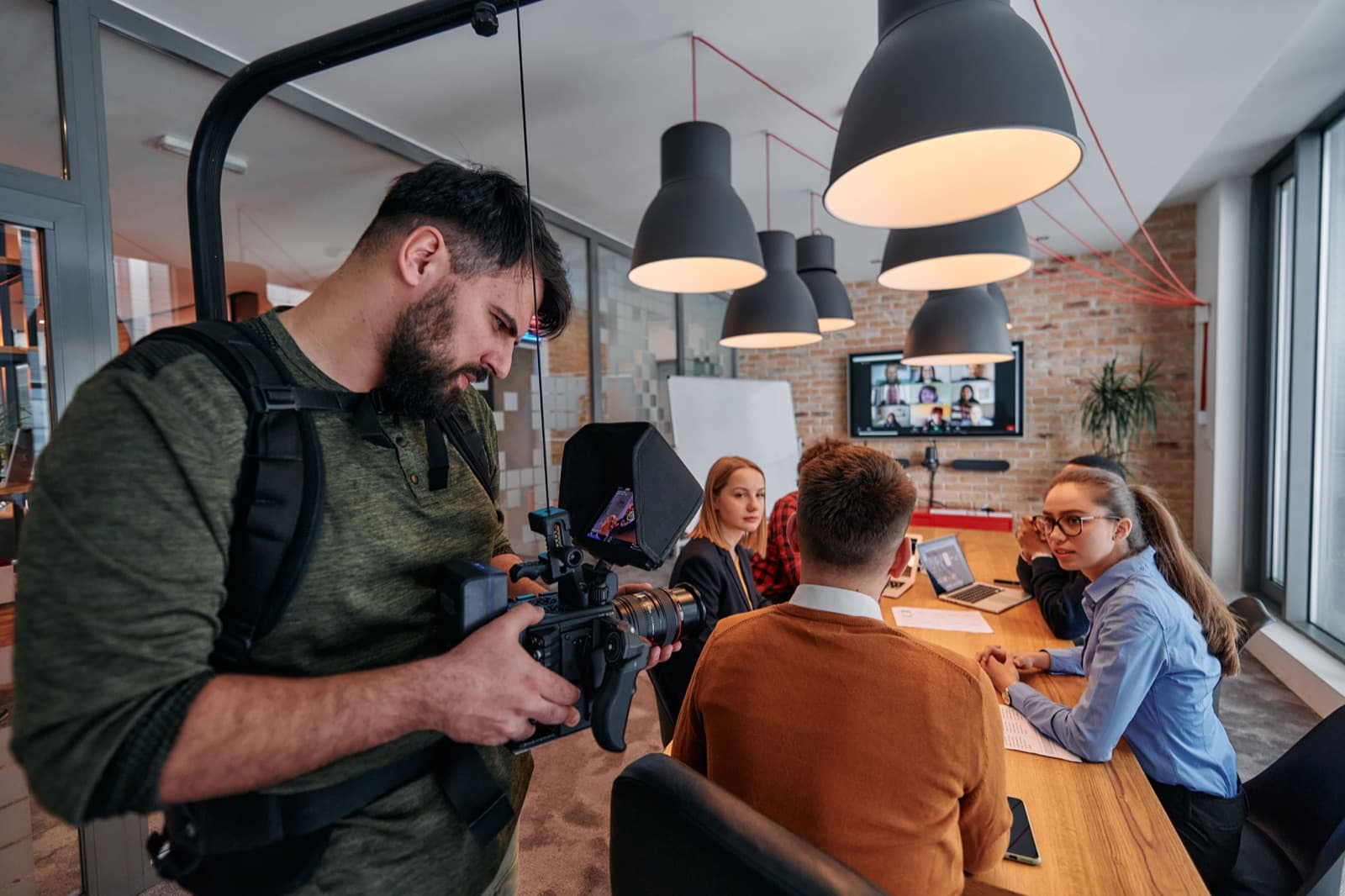 Videomaker filmando uma reunião corporativa, produção de vídeo para empresas